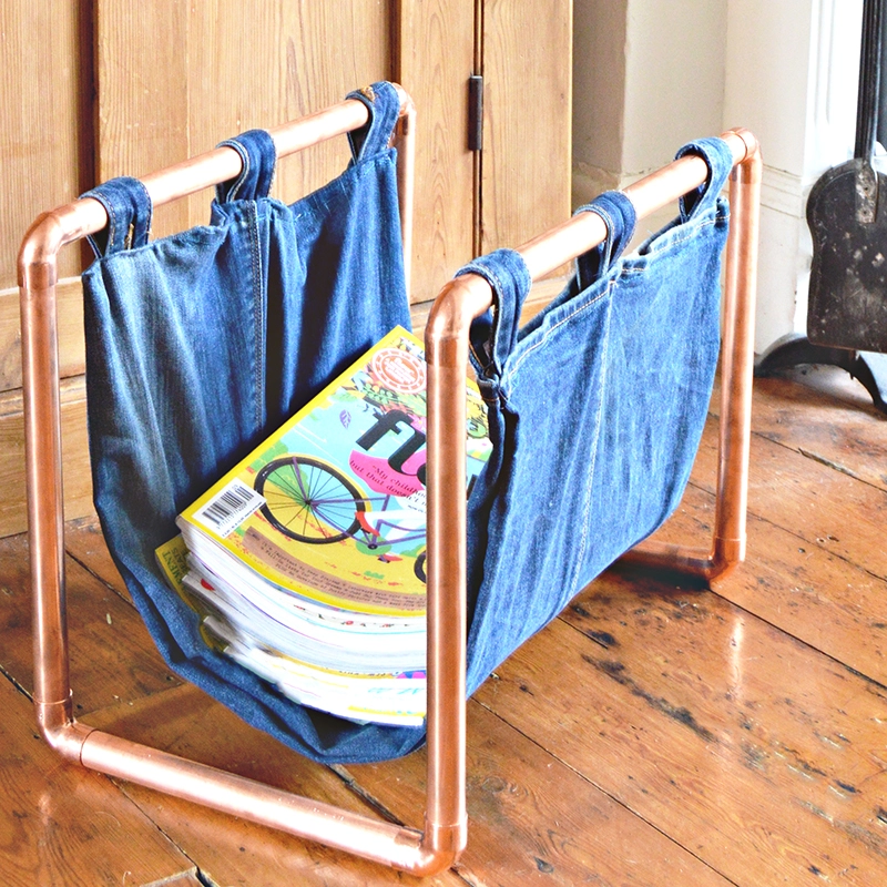 By upcycling a pair of old jeans and some copper piping, you can make this on-trend denim and copper DIY magazine rack.