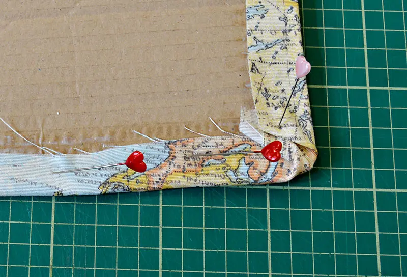 pinning the fabric to the cardboard