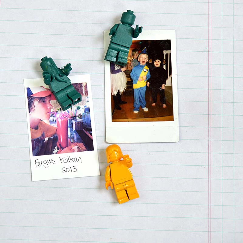 Lego figure push pins on bulletin board with photos