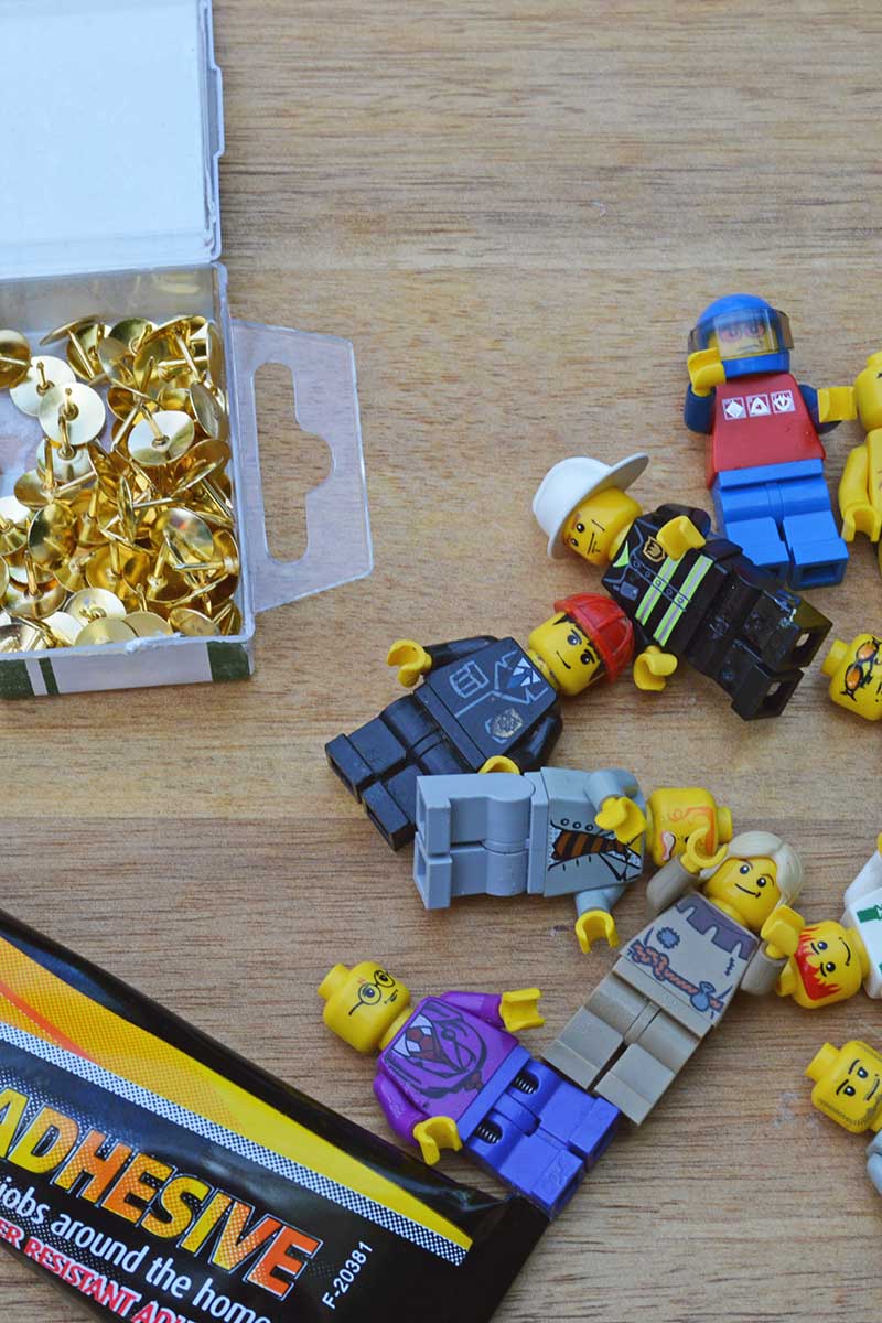 assorted LEGO Minifigures flay head push pins and glue