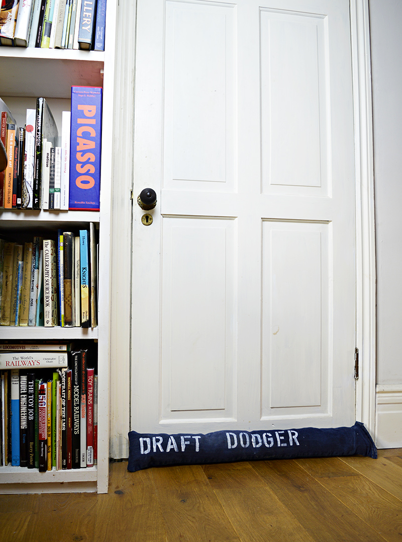 Fun stenciled upcycled denim DIY draught excluder to keep out the cold from door gaps.