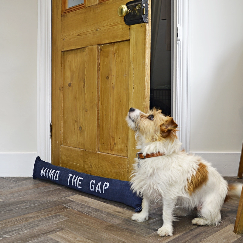 Fun stenciled upcycled denim DIY draught excluder to keep out the cold from door gaps.