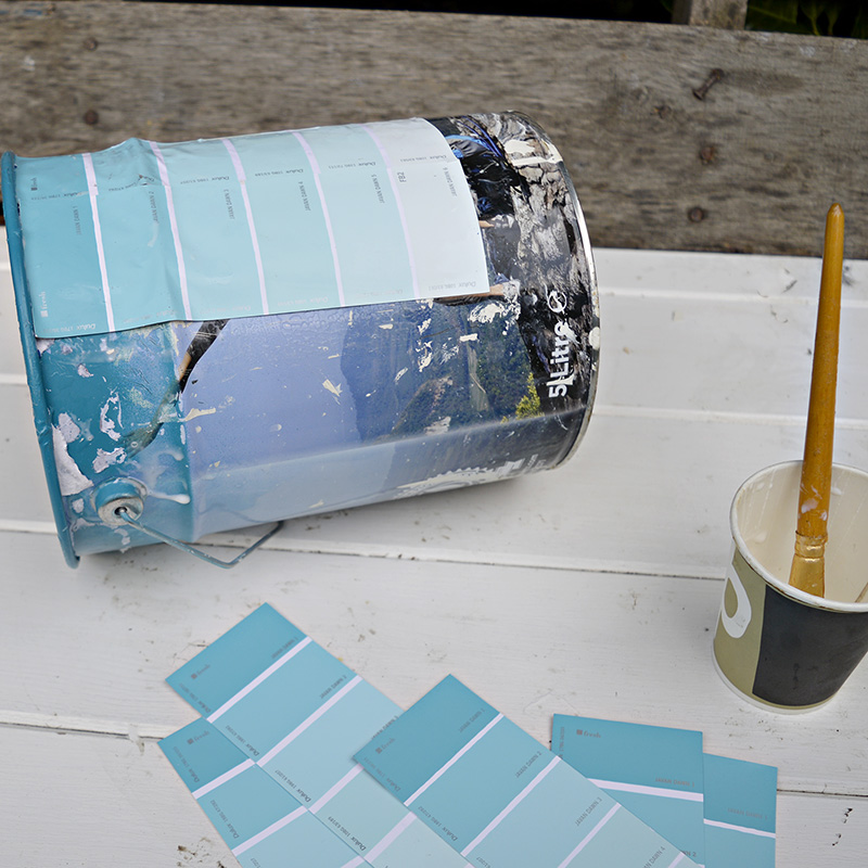 Upcycling empty paint cans by decoupaging with paint chips for an ombre effect