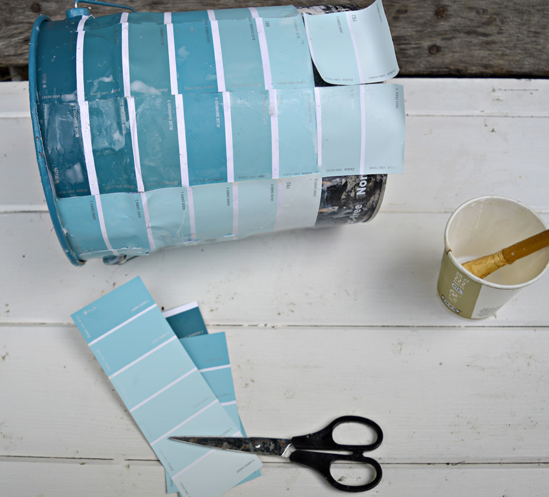 Upcycling empty paint cans by decoupaging with paint chips for an ombre effect