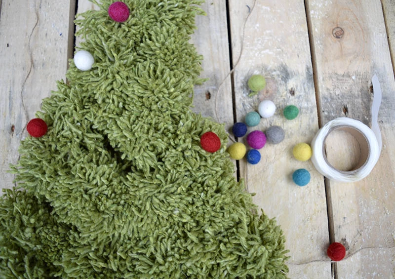 adding felt balls to pom pom Christmas tree