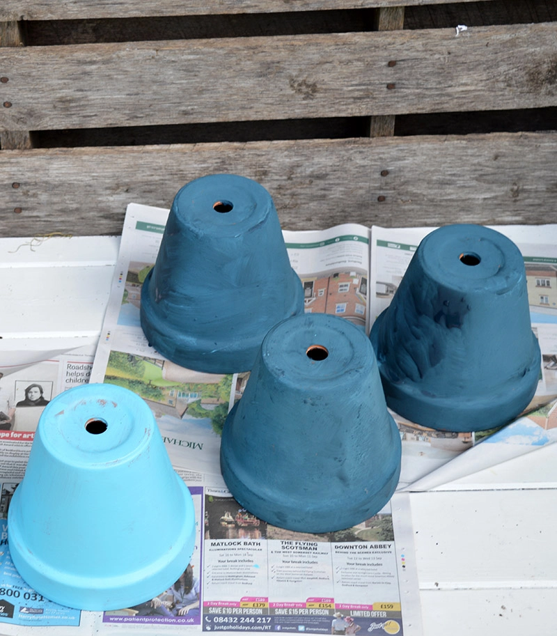 Blue painted terracotta pots for an outdoor wall planter.