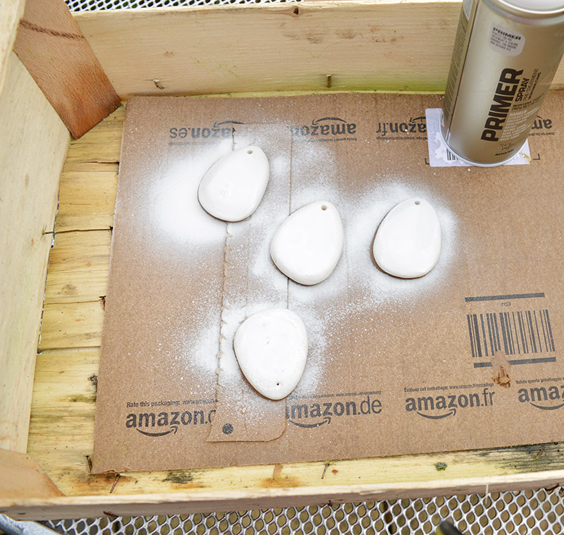 Spraying pebbles with universal primer.