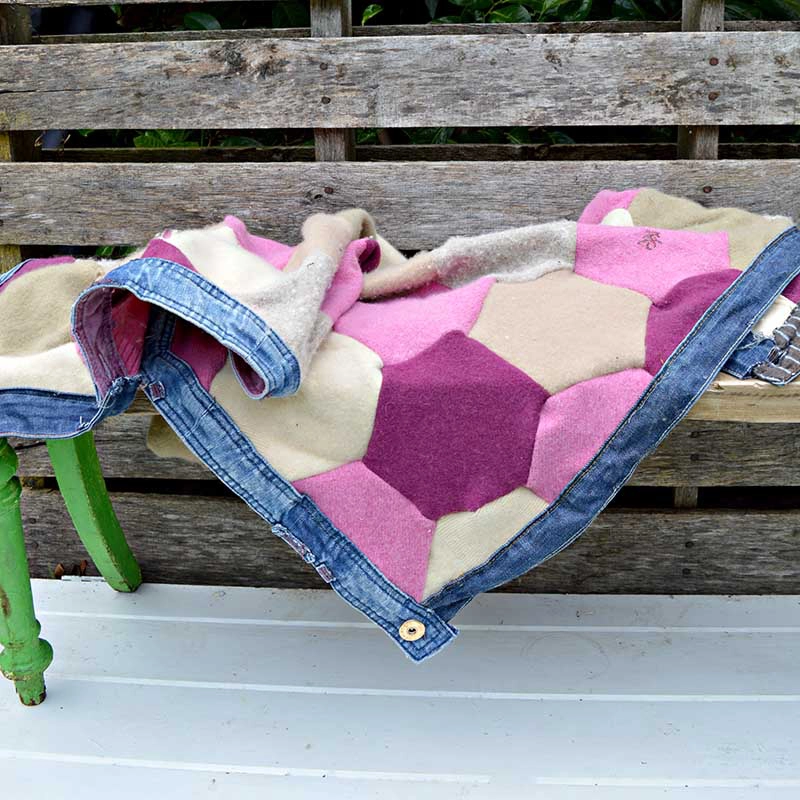 Upcycled sweater blanket made from felted wool jumpers and trimed with recycled jeans waistbands.