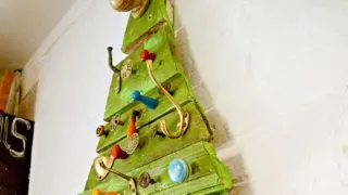 Upcycled flat Christmas tree made from reclaimed wood and cabinet knobs and hooks.