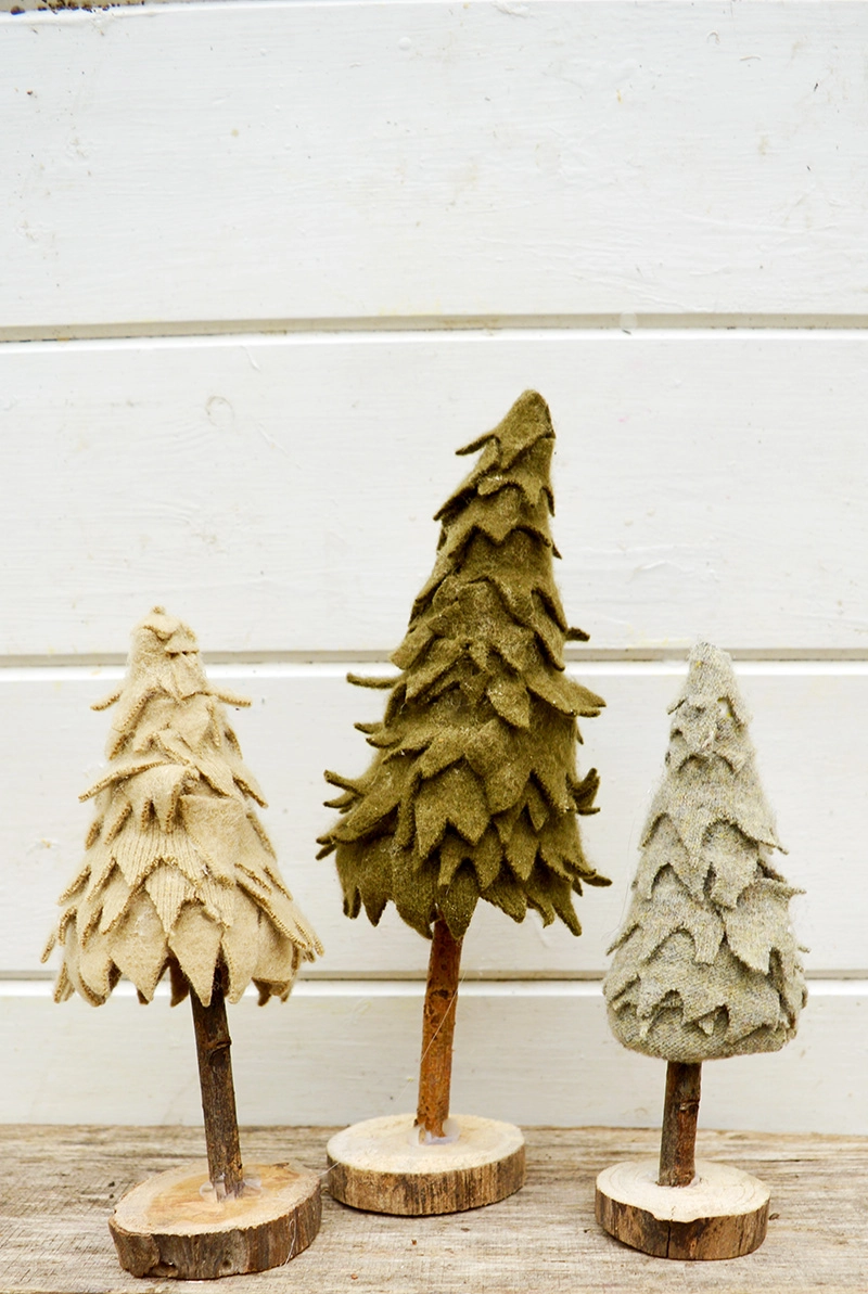 All you need is a cardboard tube a twig and some felt scraps to make these adorable felt Christmas trees.  So easy the kids can make them too!