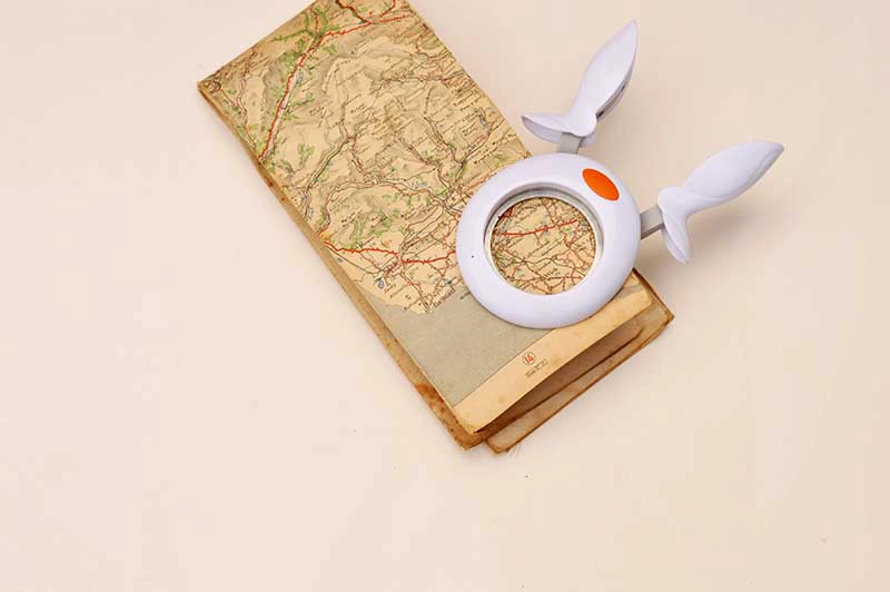 Using a paper puncher to cut circles out of old road maps.