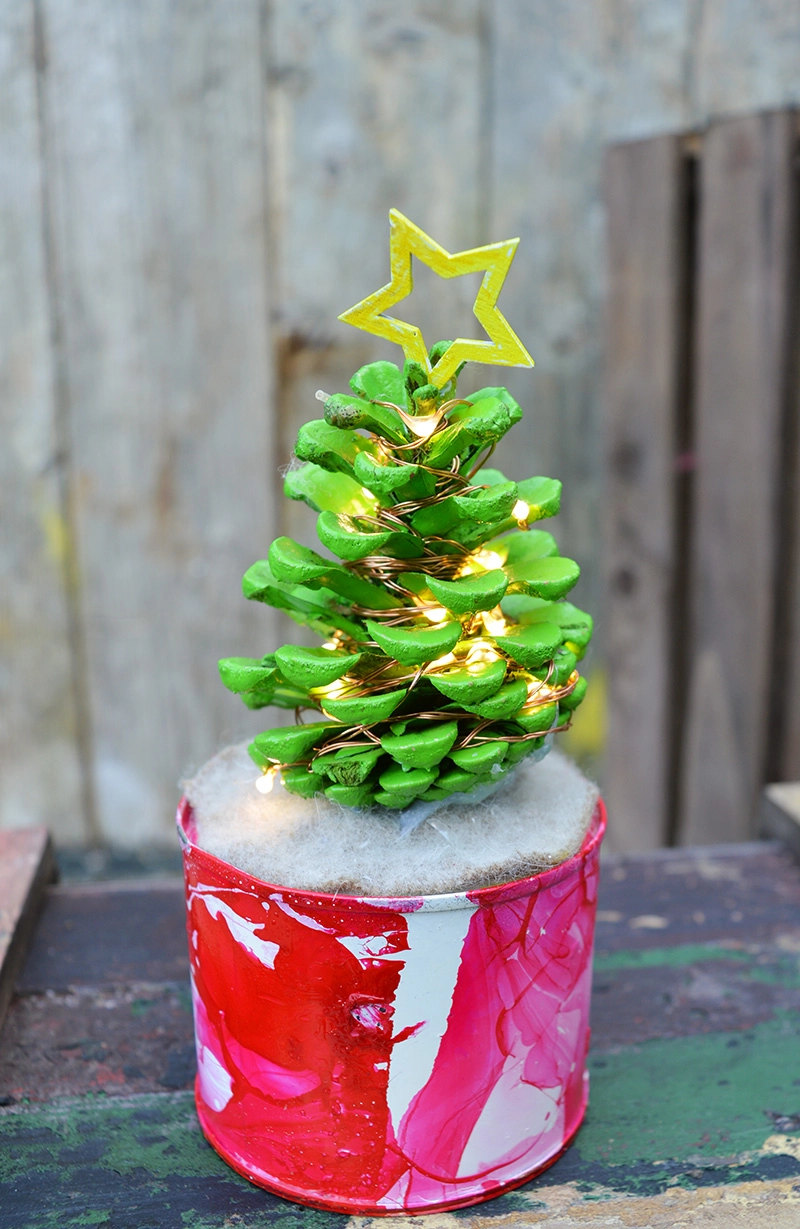 Great craft to do with the kids, make desk top illuminated mini pine cone Christmas trees.