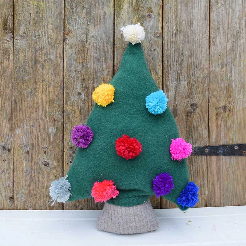 Make a really cute Christmas tree pillow from an old green sweater.  Add fun and colourful decorations to the sweater tree with pom poms.