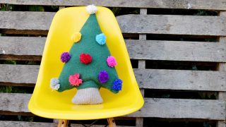 Repurpose an old sweater into a cute Christmas tree pillow with pom pom decorations