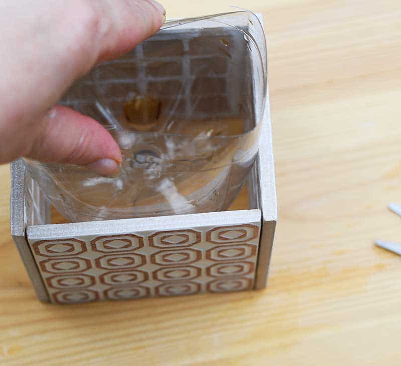 Squeezing bottle into Moroccan tile planter.