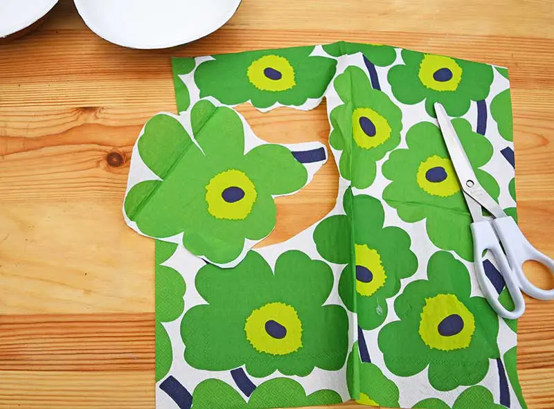 Cutting out Marimekko flower for decoupage on wood