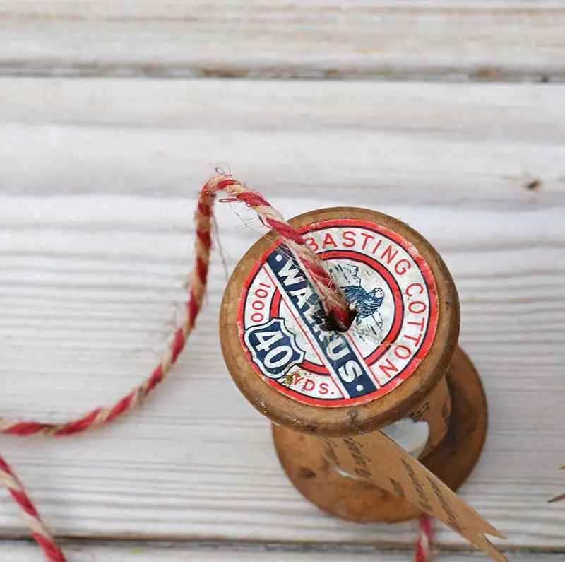 threading wooden spool with twine