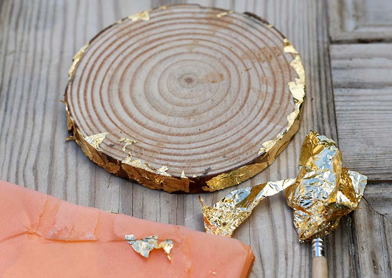 Adding gold leaf to wood slice bark