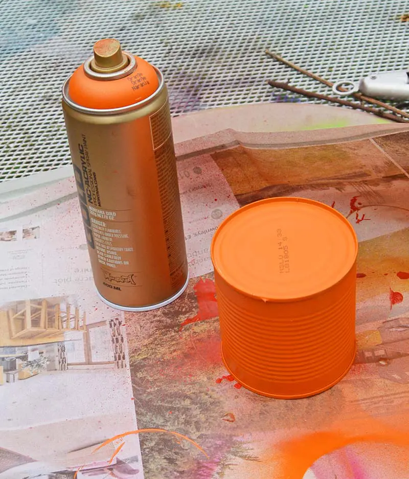 spray painting tin cans orange
