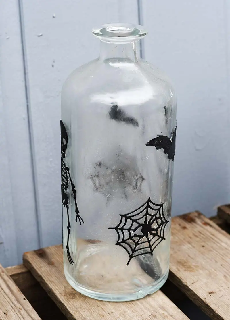 Sticking Halloween die cuts on bottle