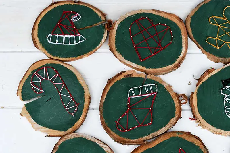 String art ornaments on wood slices