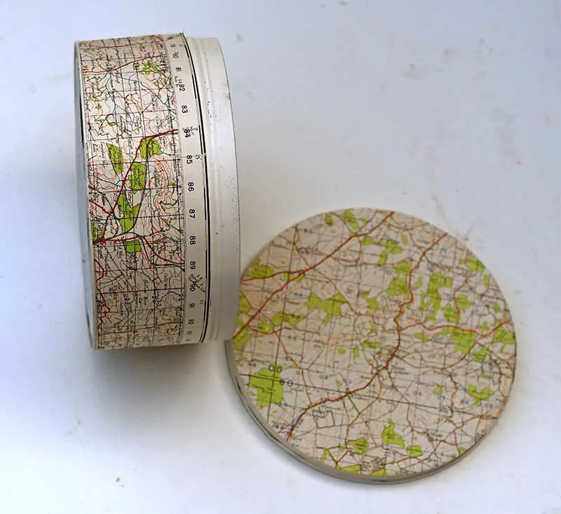 covering empty cookie tins with maps