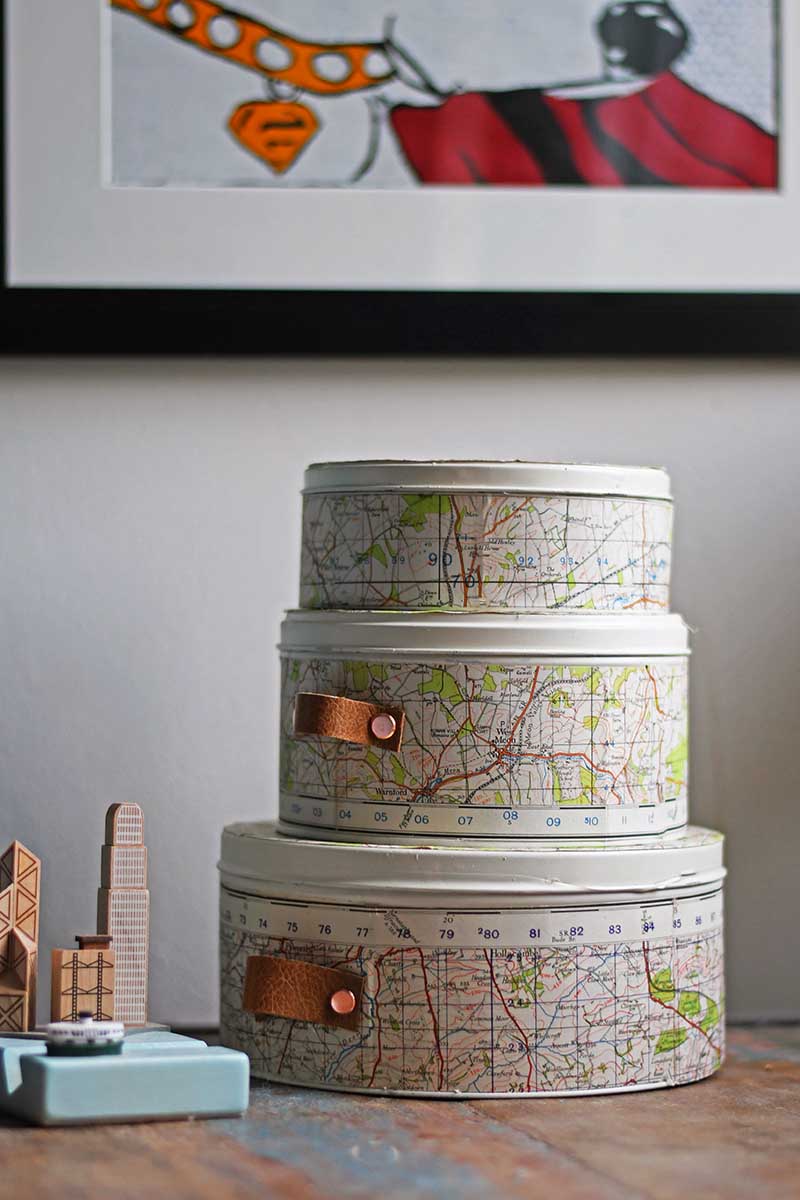 Repurposed empty cookie tins with maps