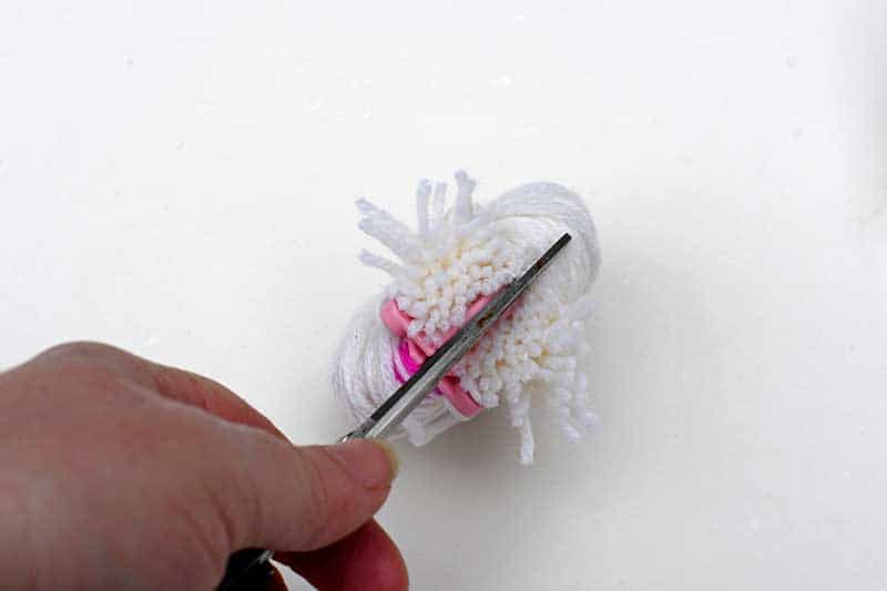 Cutting the yarn on a pom pom maker