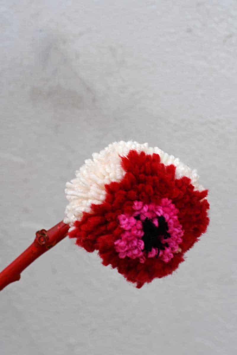 Gluing pom pom flowers to sticks