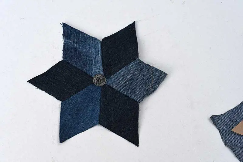 adding a button to upcycled denim quilted stars.