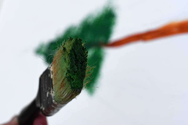 Green paint on the tip of the paint brush.