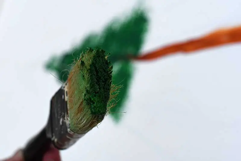 Green paint on the tip of the paint brush.