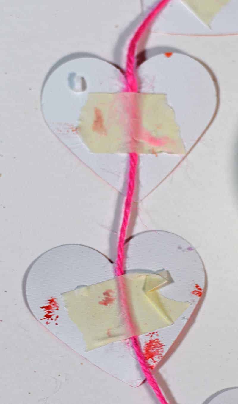 Fixing hearts to twine with masking tape