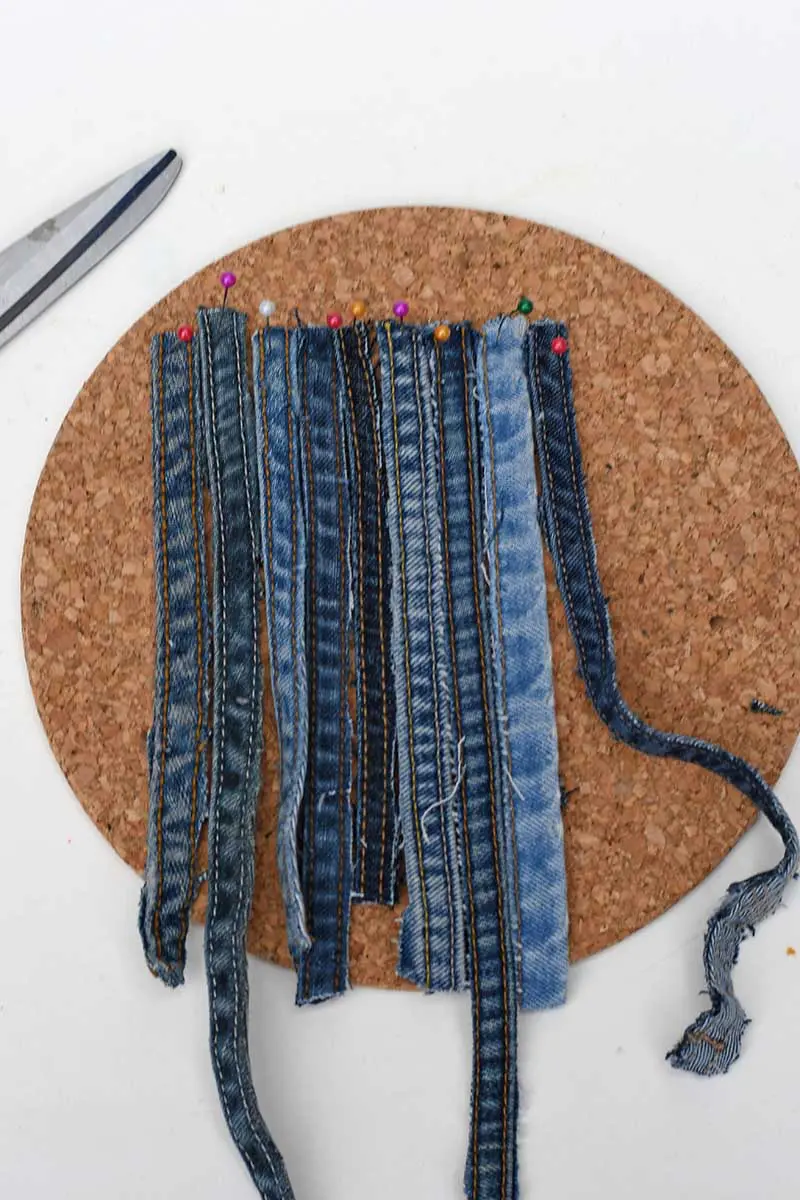 pinning the jeans seams to the cork for weaving