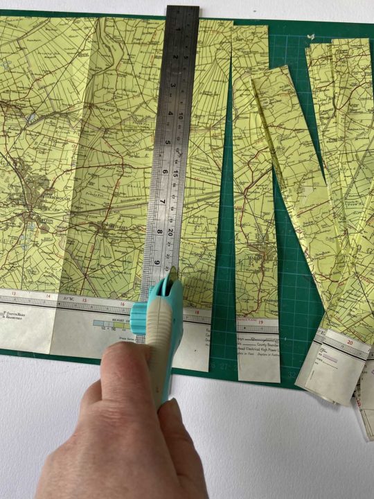 Cutting old maps into strips to make paper beads