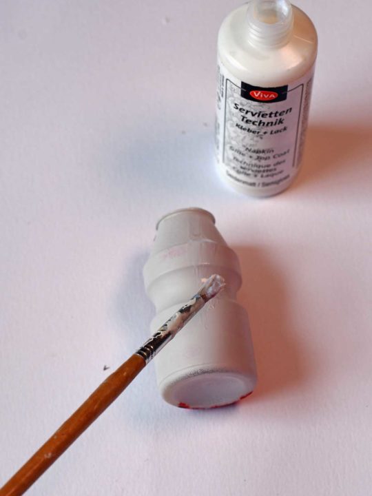 Adding decoupage glue to painted Yakult bottle