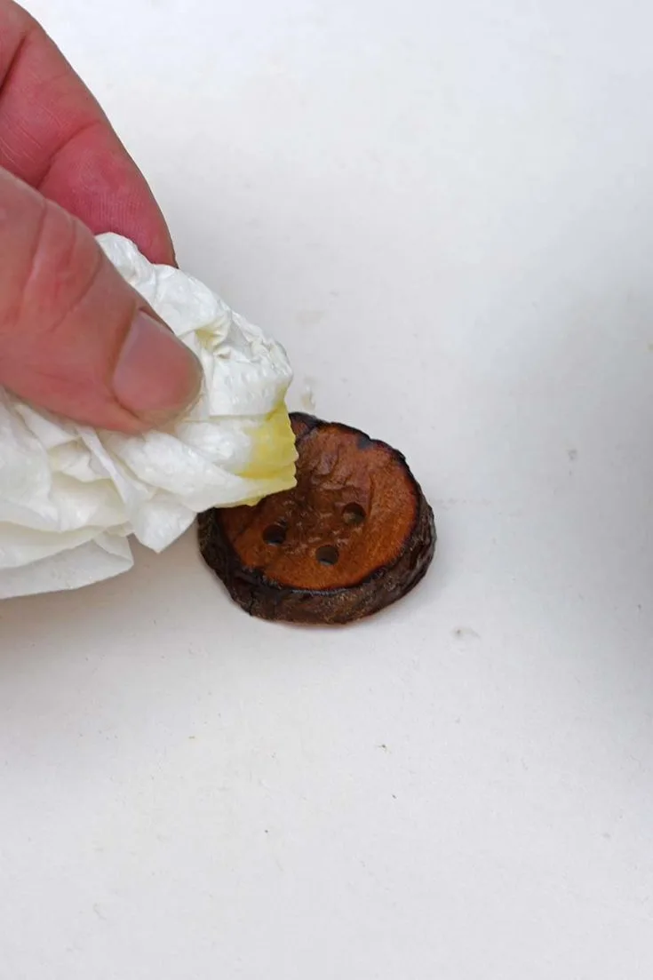 Rubbing diy avocado button with homemade oil and vinegar polish