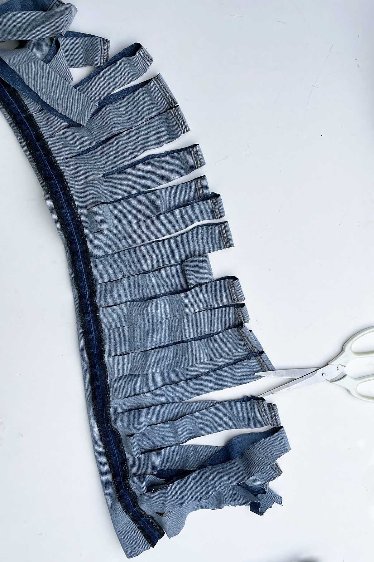 Fringing the leg of a pair of jeans with scissors