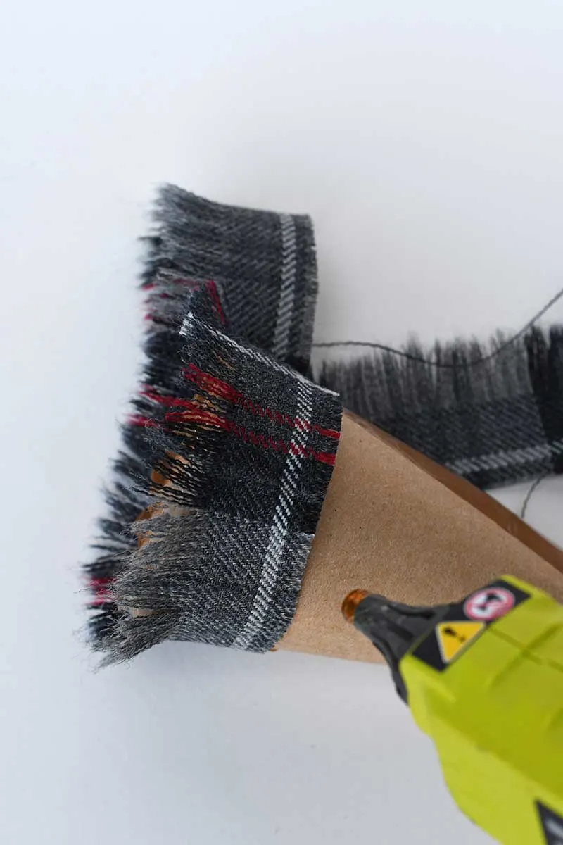 Gluing tartan fabric to the cardboard cone