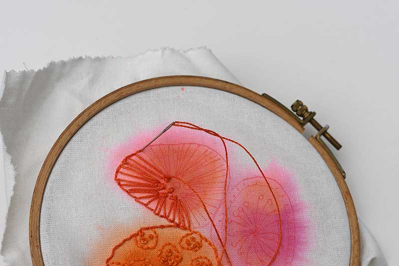 close up embroidery on painted fabric.