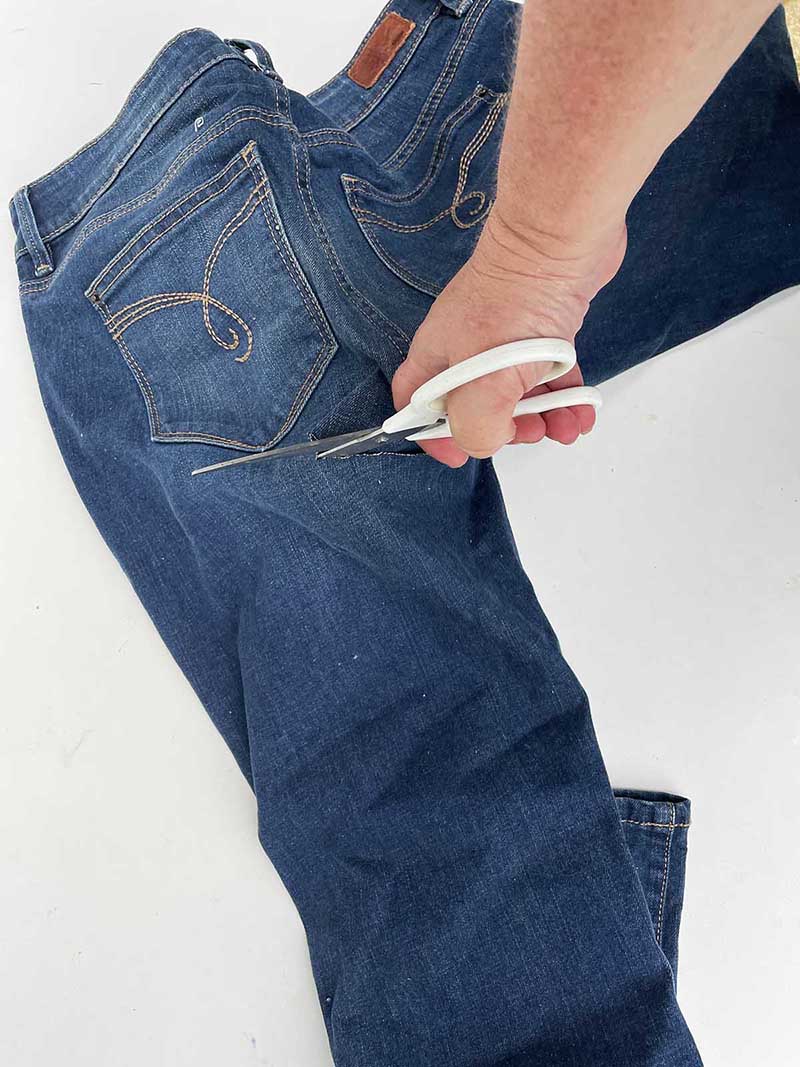 Cutting the leg of a pair of jeans to make a fake snake plant