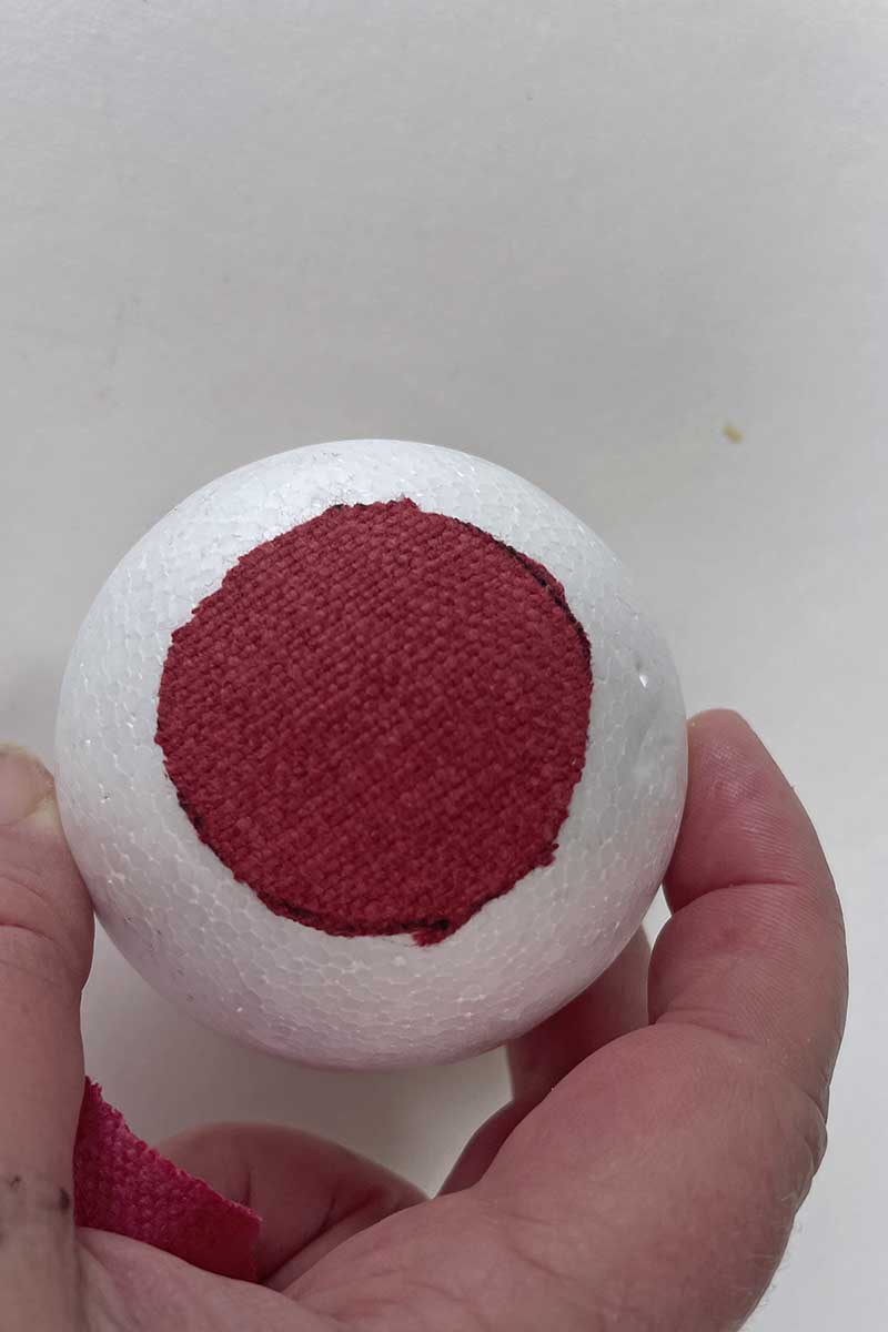 Sticking fabric into the center of the Styrofoam ball 