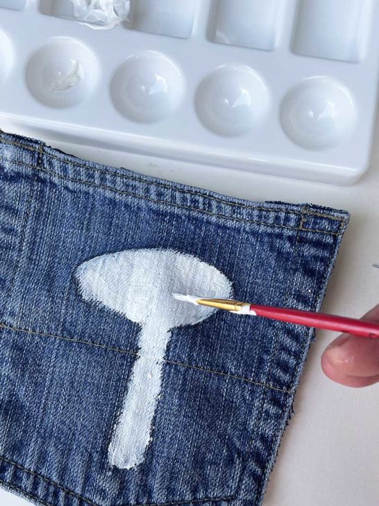 Painting white primer background on denim pockets