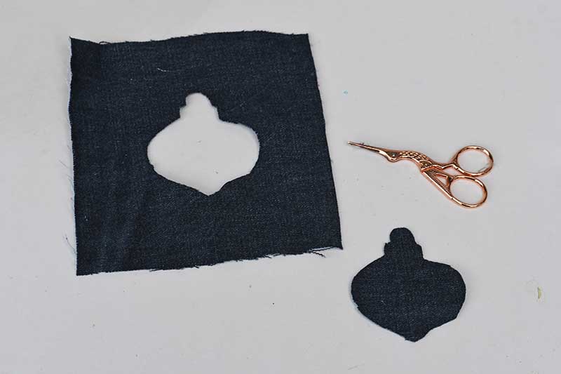 Cutting out the Christmas shape from the denim square