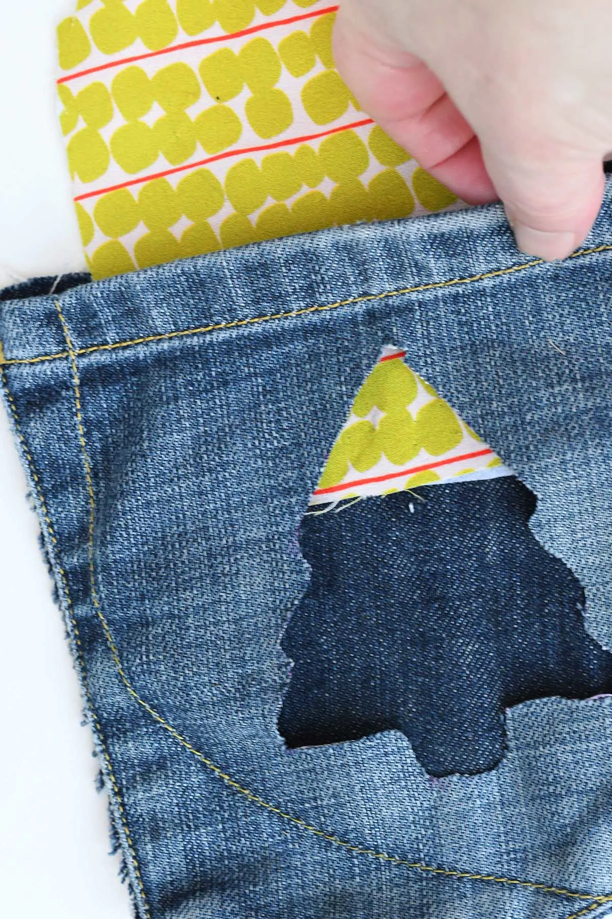 Putting fabric behind hole in jeans pocket