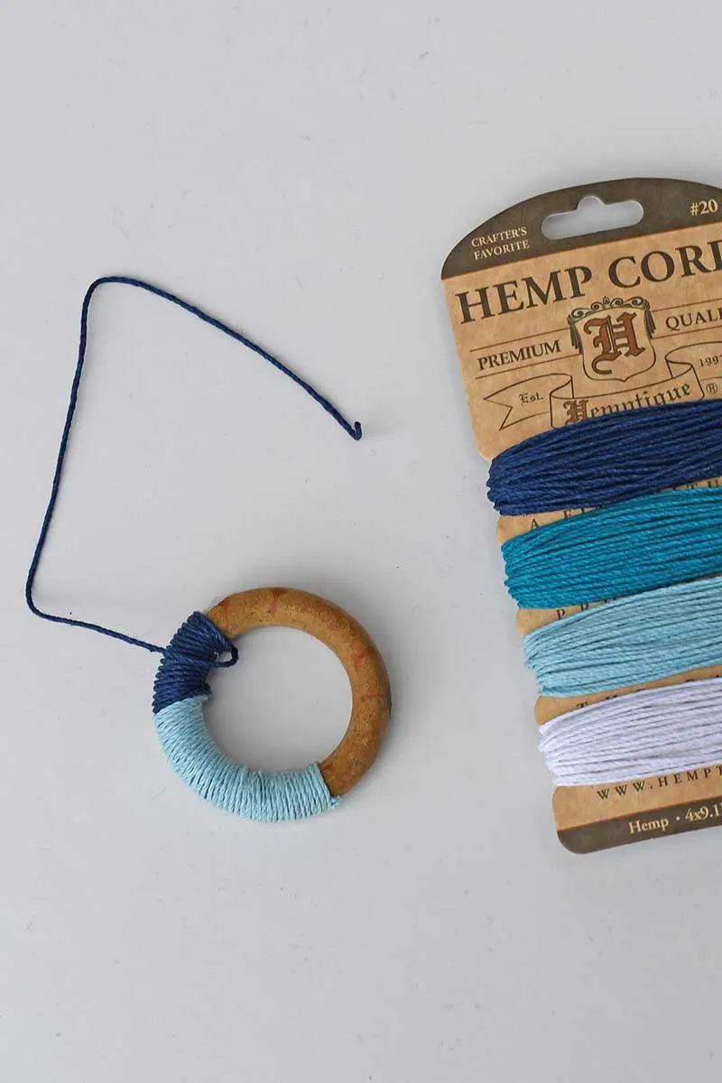 wrapping the wooden ring with coloured hemp cord.