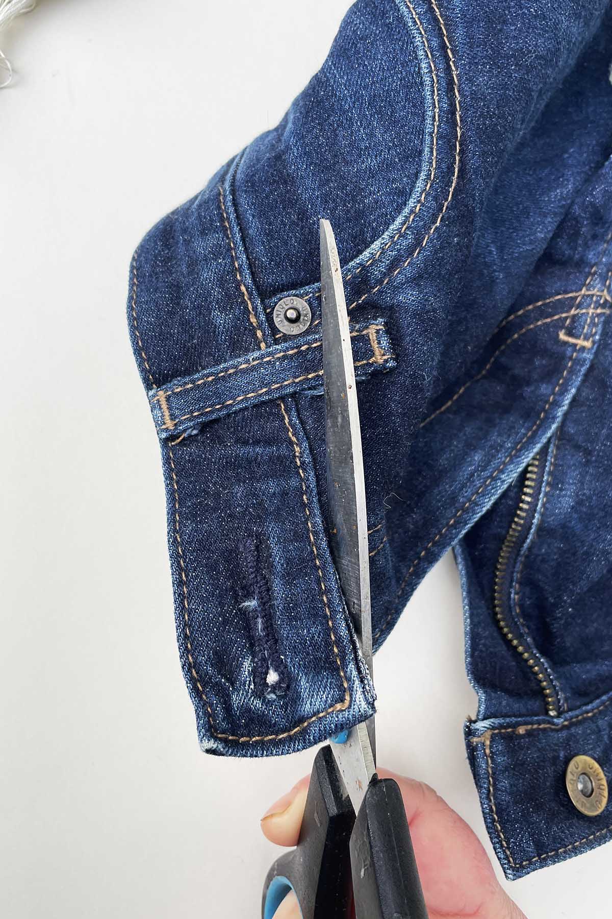cutting the denim waistband off a pair of jeans with scissors