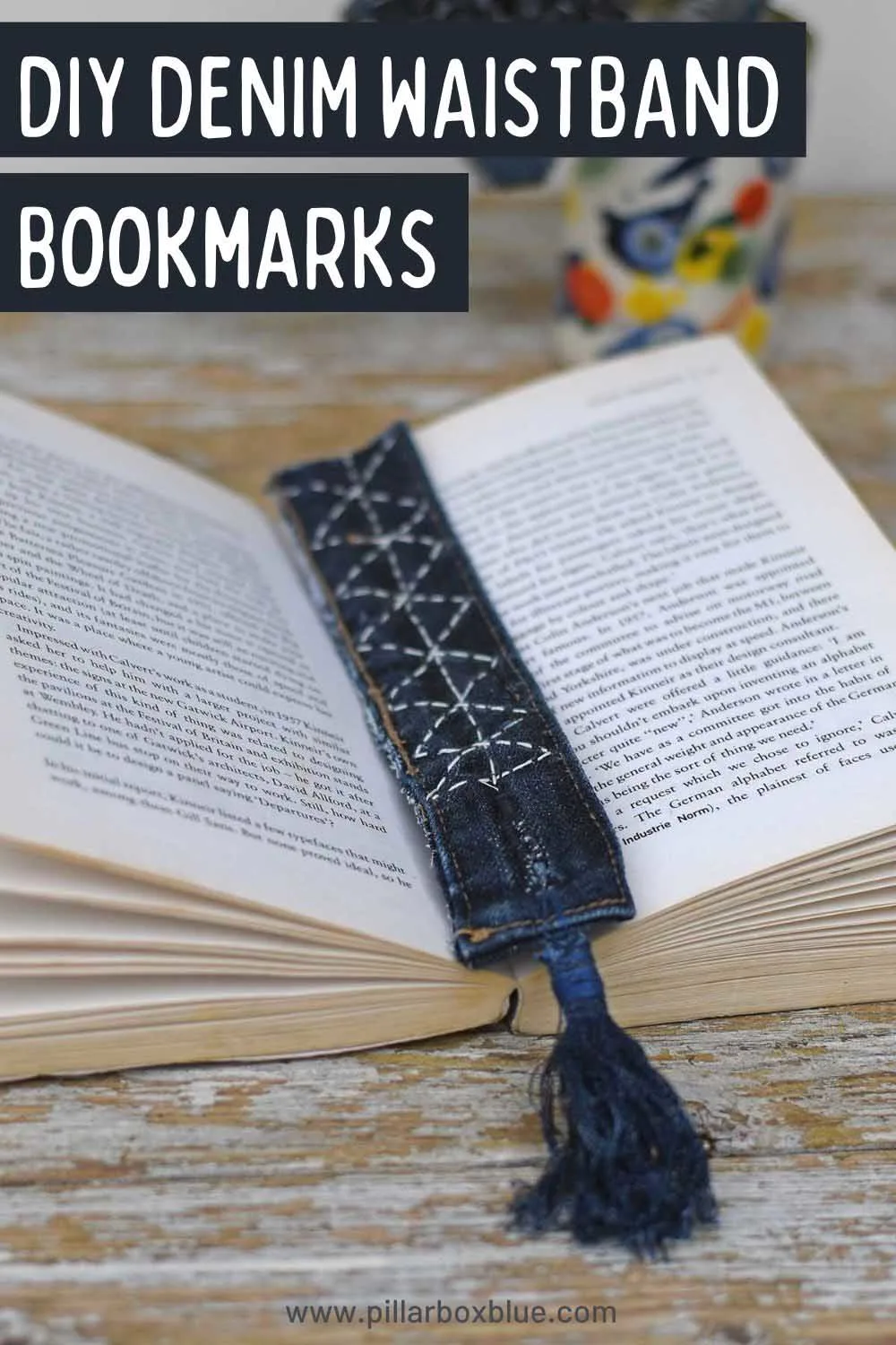 Denim waistband bookmark with tassel and Diamond pattern Sashiko stitching on an open book pin