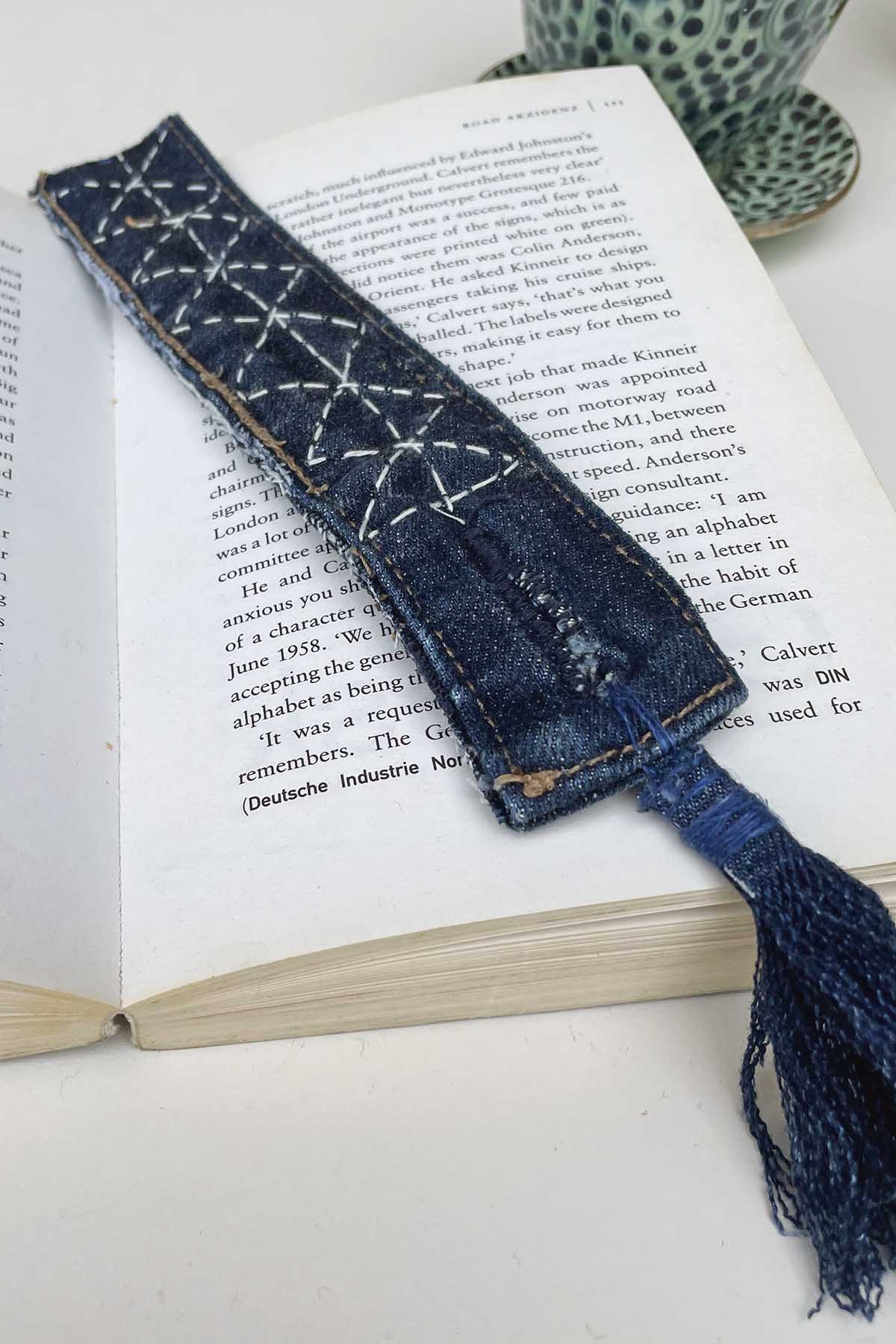 Diamond pattern Sashiko stitched denim bookmark on book