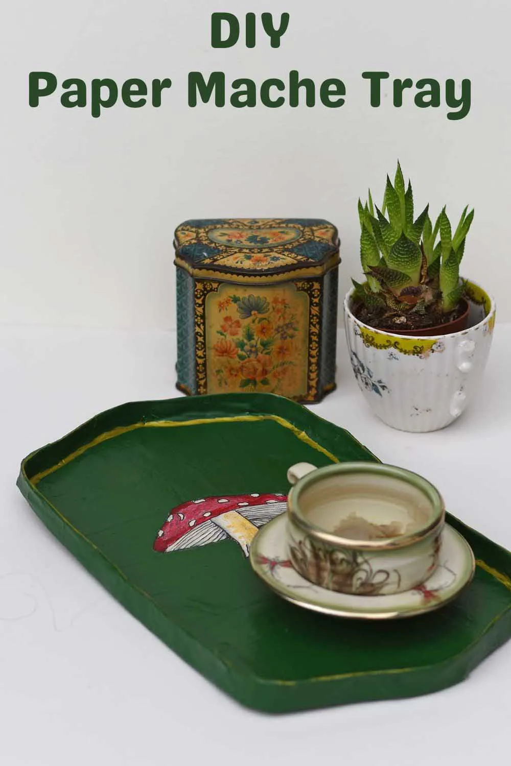 DIY paper mache tray with tea cup and caddy and plant in background